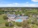Panoramic aerial view of a community showcasing the clubhouse with pool, golf course, and residential area at 11631 Wayside Willow Ct, Hudson, FL 34667