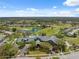 Sprawling aerial view of golf course community with clubhouse, lake, and homes at 11631 Wayside Willow Ct, Hudson, FL 34667