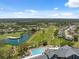 Beautiful aerial view of community pool, lake, and golf course on a sunny day at 11631 Wayside Willow Ct, Hudson, FL 34667