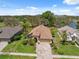 Aerial view of the property highlighting the manicured lawn, paver driveway, and ideal location near a lake at 11631 Wayside Willow Ct, Hudson, FL 34667