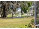 Picturesque backyard view with a tranquil pond and fountain, framed by lush trees and manicured lawn at 11631 Wayside Willow Ct, Hudson, FL 34667