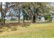Expansive backyard with mature trees creating shade, overlooking a golf course for a serene view at 11631 Wayside Willow Ct, Hudson, FL 34667