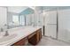 Bright bathroom featuring double sinks, wood cabinets, a glass-enclosed shower, and a soaking tub at 11631 Wayside Willow Ct, Hudson, FL 34667