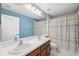 Well-lit bathroom featuring a double sink vanity, a mirror, and a shower/tub combo at 11631 Wayside Willow Ct, Hudson, FL 34667