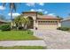 Charming home with a well-manicured lawn, beautiful brick driveway, and a two-car garage at 11631 Wayside Willow Ct, Hudson, FL 34667