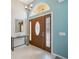 Inviting foyer featuring a stylish front door, chandelier, accent table, and tile flooring at 11631 Wayside Willow Ct, Hudson, FL 34667