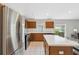 The kitchen has wooden cabinets, stainless steel appliances, a kitchen island with a breakfast bar, and tile flooring at 11631 Wayside Willow Ct, Hudson, FL 34667