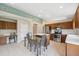 Bright kitchen features tile flooring, wooden cabinets, stainless steel appliances, and a kitchen island with a dining table at 11631 Wayside Willow Ct, Hudson, FL 34667
