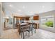 Bright kitchen features tile flooring, wooden cabinets, stainless steel appliances, and a kitchen island with a dining table at 11631 Wayside Willow Ct, Hudson, FL 34667