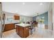 Bright kitchen features tile flooring, wooden cabinets, stainless steel appliances, and a kitchen island with a dining table at 11631 Wayside Willow Ct, Hudson, FL 34667