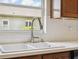 A kitchen sink is accented by a modern faucet, pristine white countertops, and wood cabinets, offering a blend of utility and elegance at 11631 Wayside Willow Ct, Hudson, FL 34667
