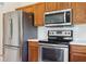 This kitchen is equipped with stainless steel appliances and wooden cabinets, blending functionality with classic design at 11631 Wayside Willow Ct, Hudson, FL 34667