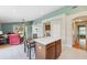 Features a kitchen island with a dining table that is next to an archway to a living room with views of the exterior at 11631 Wayside Willow Ct, Hudson, FL 34667