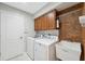 Laundry room with wooden cabinets, a sink, and a washer and dryer at 11631 Wayside Willow Ct, Hudson, FL 34667