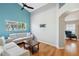 Spacious living room featuring hardwood floors, two sofas, large windows, and an arched doorway at 11631 Wayside Willow Ct, Hudson, FL 34667