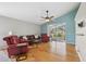 This living room includes hardwood floors, red couches, a ceiling fan, and large windows overlooking the outdoors at 11631 Wayside Willow Ct, Hudson, FL 34667