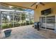Enclosed patio with brick floors, ceiling fan, outdoor grill, and view of nature at 11631 Wayside Willow Ct, Hudson, FL 34667