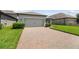 A close-up view shows a brick-paved driveway leading to the home's attached two-car garage at 12272 Rangeland Blvd, Odessa, FL 33556