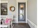 Close-up of the front door with decorative wreath and rocking chair, offering a welcoming and inviting entrance at 12272 Rangeland Blvd, Odessa, FL 33556