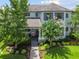 Charming two-story home featuring a landscaped yard with flowering trees and a brick walkway at 12272 Rangeland Blvd, Odessa, FL 33556