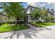 Inviting two-story home featuring a covered front porch, meticulously landscaped yard, and stone accents at 12272 Rangeland Blvd, Odessa, FL 33556