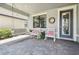 Charming front porch featuring a porch swing, rocking chairs and a decorative wreath adorning the entrance at 12272 Rangeland Blvd, Odessa, FL 33556