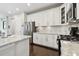 Modern kitchen with white cabinets, stainless steel appliances, granite countertops, and a tiled backsplash, exuding sophistication at 12272 Rangeland Blvd, Odessa, FL 33556