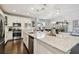 Bright kitchen featuring white cabinetry, granite countertops, stainless steel appliances, and a view into the dining area at 12272 Rangeland Blvd, Odessa, FL 33556
