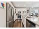 Well-appointed kitchen with stainless steel refrigerator, white cabinets, granite counters and convenient access to the dining area at 12272 Rangeland Blvd, Odessa, FL 33556