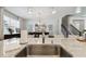 Stylish kitchen with a stainless steel sink, granite countertops, pendant lighting, and a view towards the dining area at 12272 Rangeland Blvd, Odessa, FL 33556