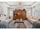 Bright living room with a vintage wooden hutch, stylish seating, and an area rug at 12272 Rangeland Blvd, Odessa, FL 33556