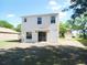 View of the back of the house with a door, windows, and an AC unit in the yard at 12431 White Bluff Rd, Hudson, FL 34669