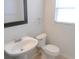 Bathroom featuring a toilet, pedestal sink, and a framed mirror at 12431 White Bluff Rd, Hudson, FL 34669