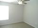 Neutral bedroom with a ceiling fan, window, and neutral carpet flooring at 12431 White Bluff Rd, Hudson, FL 34669