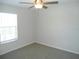 Bright bedroom featuring a ceiling fan, window, and neutral carpet flooring at 12431 White Bluff Rd, Hudson, FL 34669