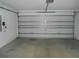 Spacious garage with white walls, concrete floor, and a white garage door at 12431 White Bluff Rd, Hudson, FL 34669