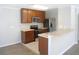 Modern kitchen with stainless steel appliances, brown cabinets, and an eat-in breakfast bar at 12431 White Bluff Rd, Hudson, FL 34669