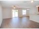 Bright and airy living room featuring hardwood floors, ceiling fan and sliding glass doors to the backyard at 12431 White Bluff Rd, Hudson, FL 34669