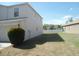 Spacious side yard with green grass and a bush near the side of the house at 12431 White Bluff Rd, Hudson, FL 34669