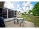 Back patio with an outdoor table set and screened in porch visible, great for relaxing outdoors at 12478 Prescott St, Spring Hill, FL 34609