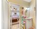 Bathroom with a white vanity and a view into the bedroom with a bed and ceiling fan at 12478 Prescott St, Spring Hill, FL 34609