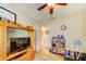 Bedroom with a wooden TV stand, a doorway to the bathroom, and a shelf of toys at 12478 Prescott St, Spring Hill, FL 34609