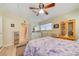 Comfortable bedroom with white furniture, features a ceiling fan, natural light, and access to an ensuite bathroom at 12478 Prescott St, Spring Hill, FL 34609
