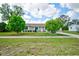 Charming home featuring a well-manicured lawn, mature trees, and a welcoming front porch at 12478 Prescott St, Spring Hill, FL 34609
