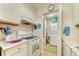 Functional galley kitchen features white appliances and granite countertops, with a view into the laundry room at 12478 Prescott St, Spring Hill, FL 34609