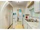 Galley kitchen with white cabinets and granite countertops, complemented by stainless steel appliances and natural light at 12478 Prescott St, Spring Hill, FL 34609