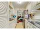 Well-lit galley kitchen with white cabinets, stainless steel appliances, and a view into the dining and living areas at 12478 Prescott St, Spring Hill, FL 34609