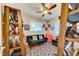 Office space with a dark blue couch, a ceiling fan, and decorative shelves for photos at 12478 Prescott St, Spring Hill, FL 34609