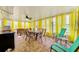 Bright sunroom with tile floors, ceiling fan, and bright yellow sheer curtains at 12478 Prescott St, Spring Hill, FL 34609
