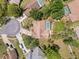 Aerial view of a home with a screened pool, surrounded by lush trees in a quiet neighborhood at 1280 Thornton Ct, Spring Hill, FL 34608